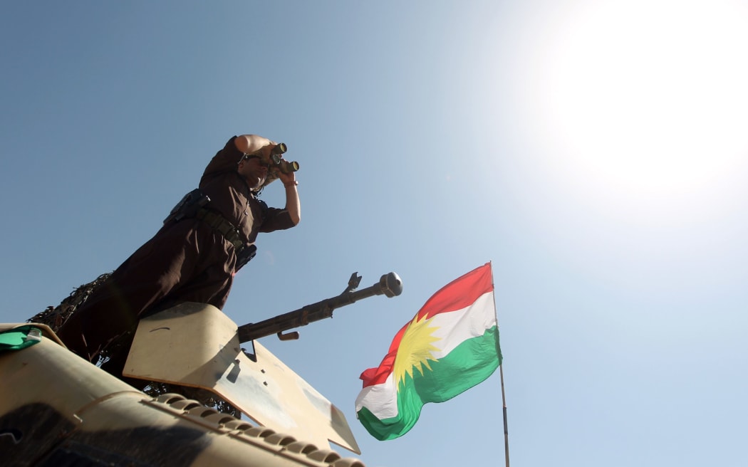 An Iraqi Kurdish Peshmerga fighter monitors the area from their front line position in Bashiqa, 13 kilometres north-east of Mosul