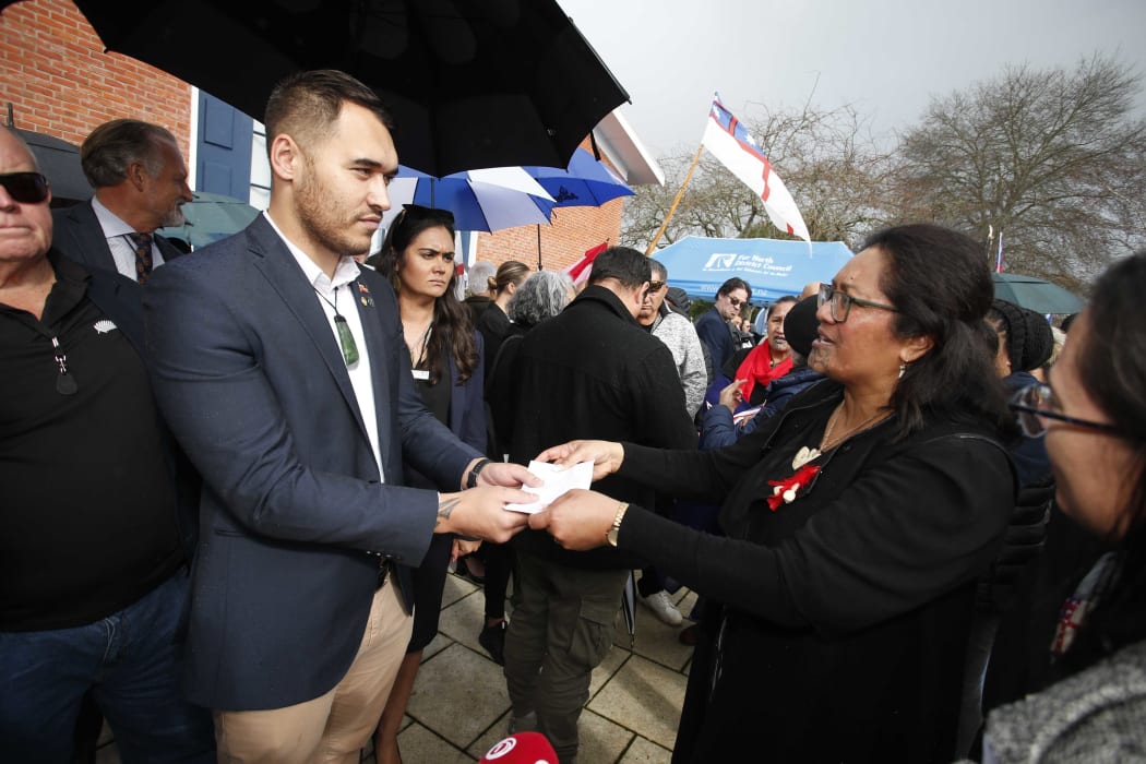 Far North councillor Moko Tepania (left) receives the Stop SNAs petition delivered by the hikoi, from Hinerangi Himiona.