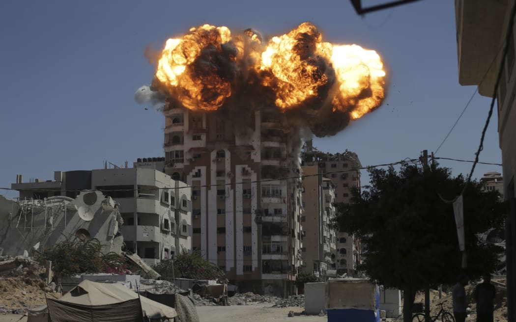 Flames erupt from a building following an Israeli military strike in Gaza City on 14 September 2025.