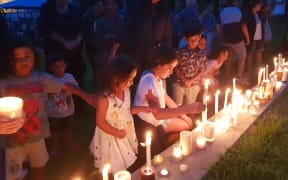 Children light candles at a vigil in Whangarei,