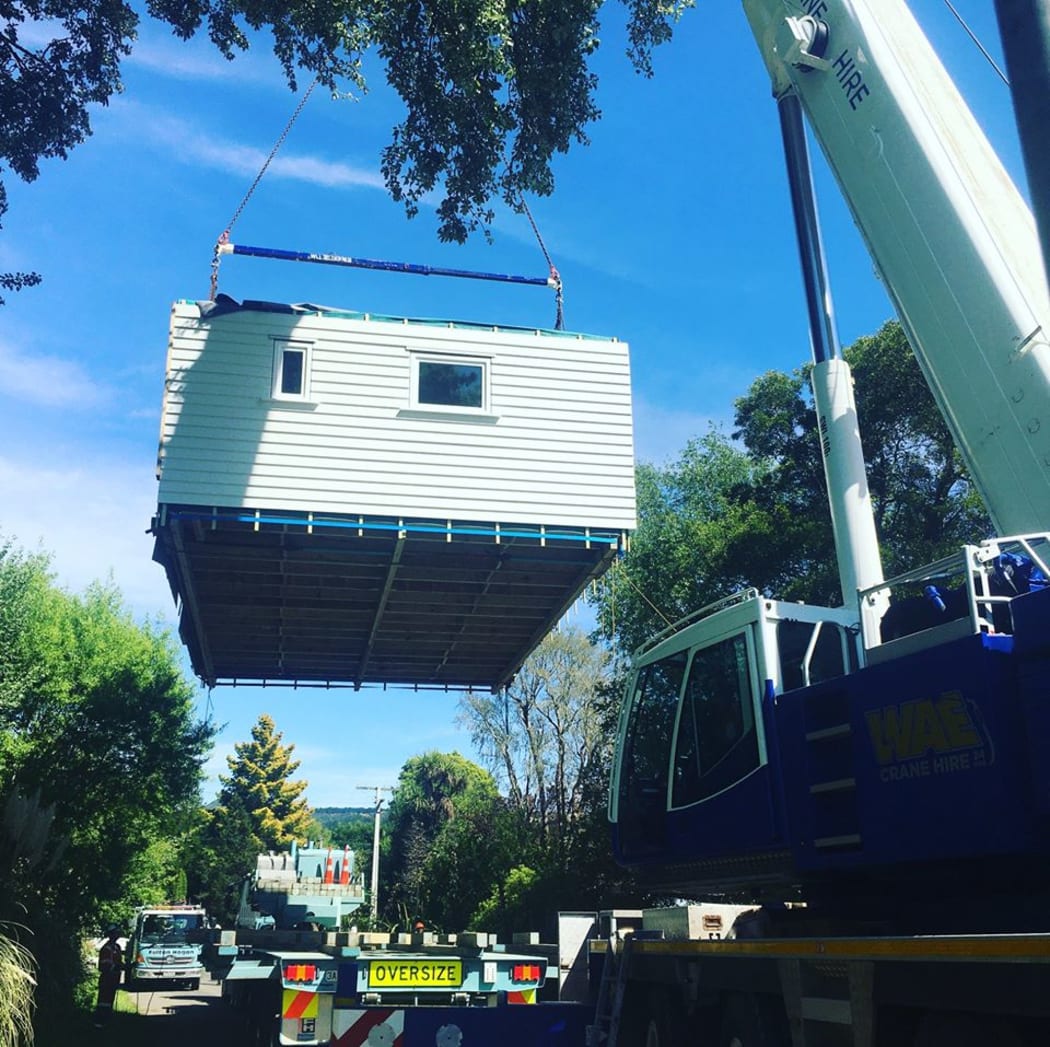The basic structure of the climate safe house being lifted into place by a crane.
