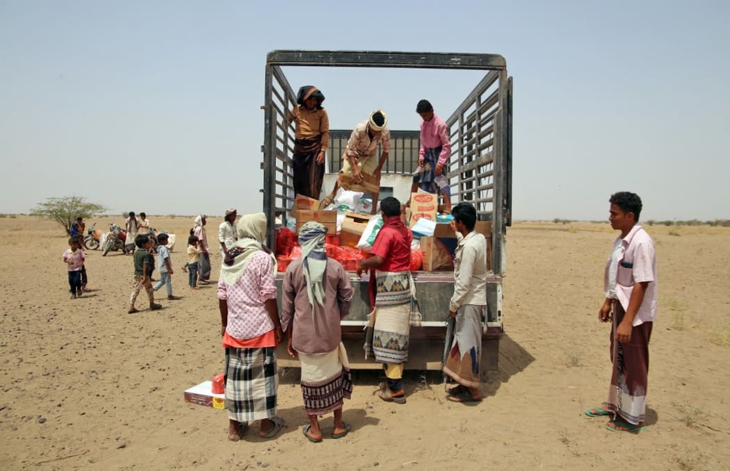 Yemenis displaced by the conflict, receive food aid and supplies to meet their basic needs, at a camp in Hays district in the war-ravaged western province of Hodeidah.