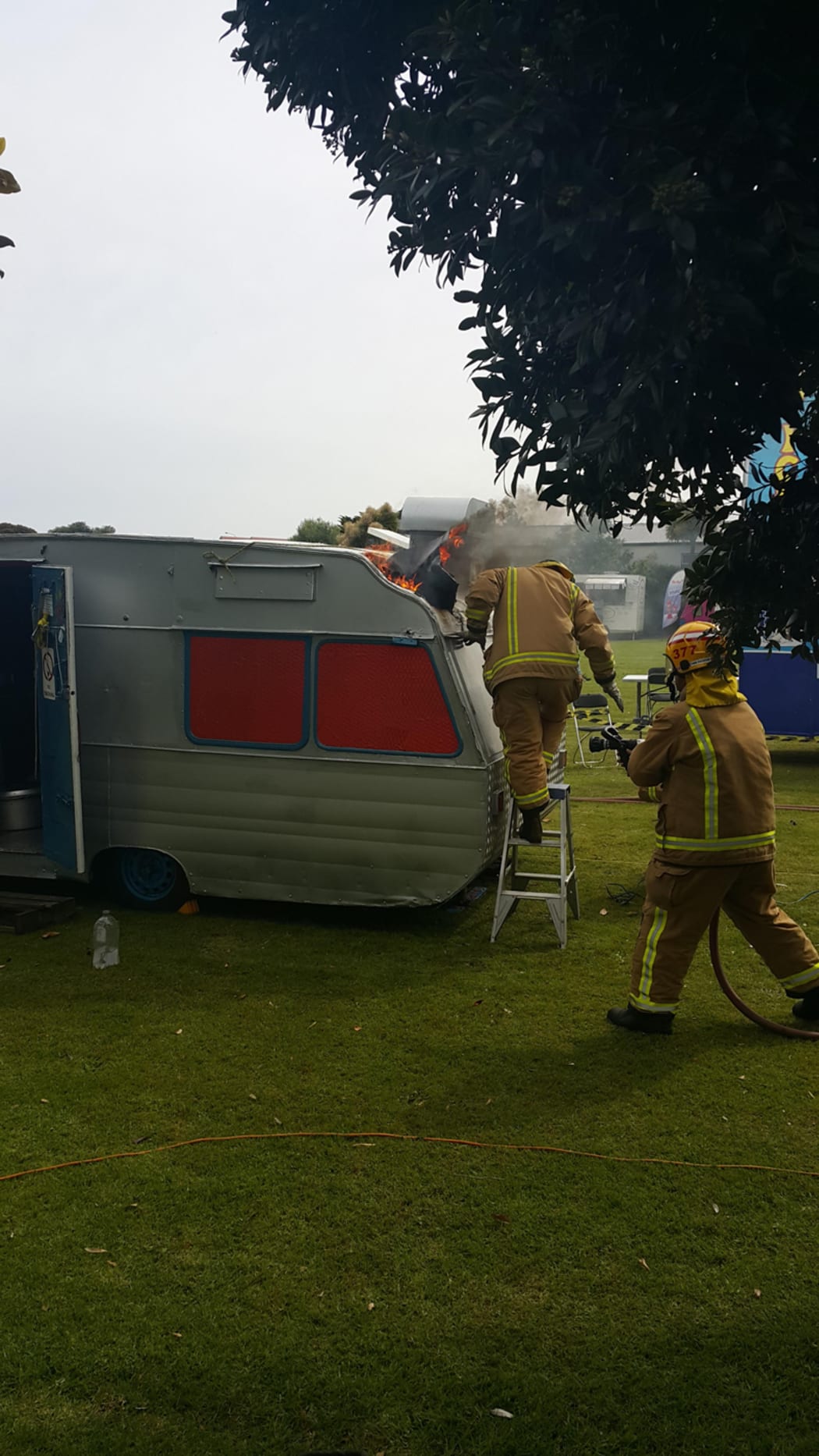 Fire fighters rush to the High Roller food caravan after it caught fire at the Kapiti strawberry festival.