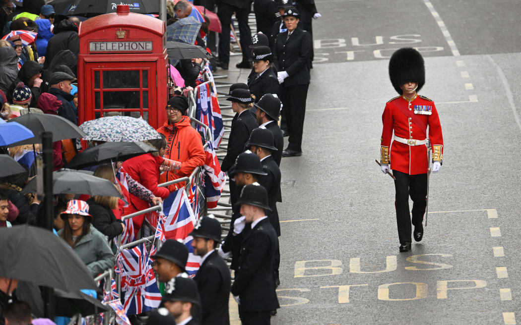 Police officers line the route of the 'King's Procession', a journey of two kilometres from Buckingham Palace to Westminster Abbey in central London on May 6, 2023, ahead of the coronations of Britain's King Charles III and Britain's Camilla, Queen Consort. - The set-piece coronation is the first in Britain in 70 years, and only the second in history to be televised. Charles will be the 40th reigning monarch to be crowned at the central London church since King William I in 1066. Outside the UK, he is also king of 14 other Commonwealth countries, including Australia, Canada and New Zealand. Camilla, his second wife, will be crowned queen alongside him, and be known as Queen Camilla after the ceremony. (Photo by SEBASTIEN BOZON / POOL / AFP)