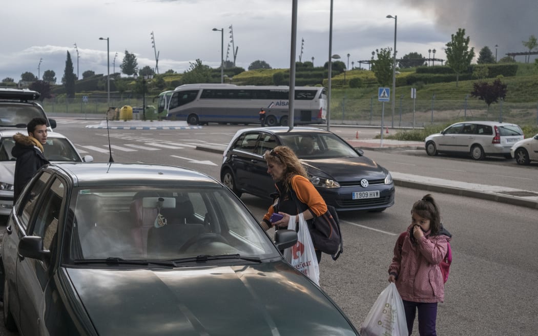 A family evacuate a residential area in Sesena, Spain, affected by the toxic fumes produced by tyres burning in an uncontrolled dump near the town.