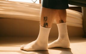 A pair of masculine calves in white socks.