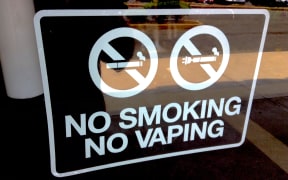 A sign in bold lettering reading "No Smoking / No Vaping".