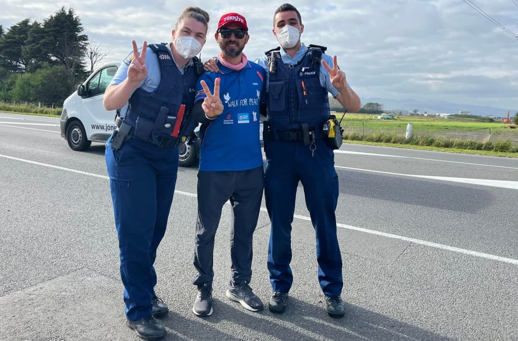 Temel Atacocugu with 2 police officers on his Walk for Peace on outskirts of Christchurch
