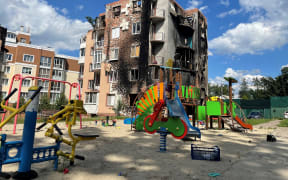 War ravaged apartment building with a playground