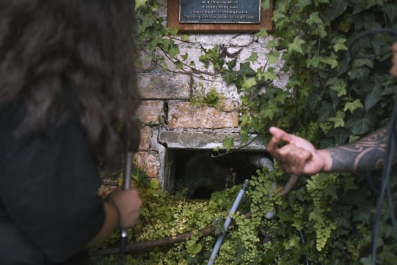 Ngarimu Blair (right) shows Kahu Kutia a sacred spring Te Wai Ariki, hidden away behind a brick wall in a University of Auckland carpark.