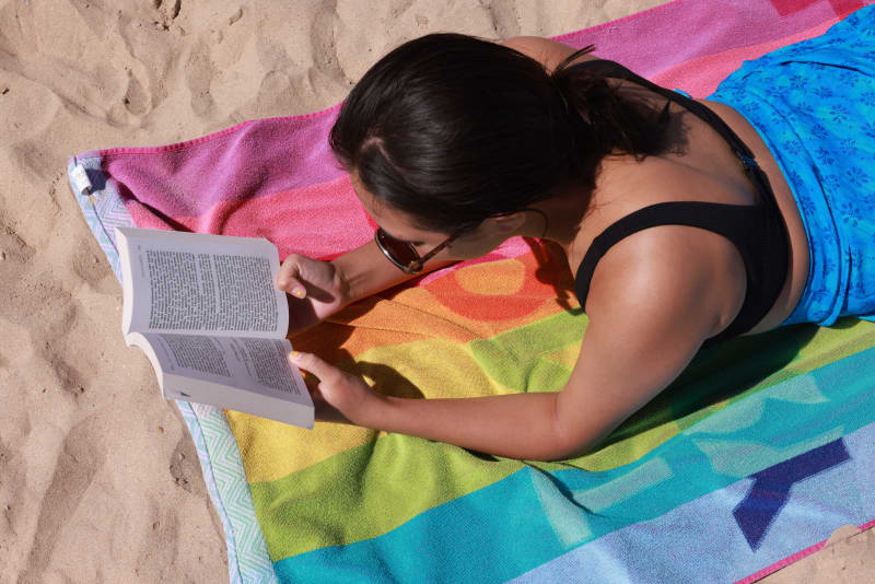 A woman reads a book on the beach. Illustration reading, summer, summer holidays and tourism.