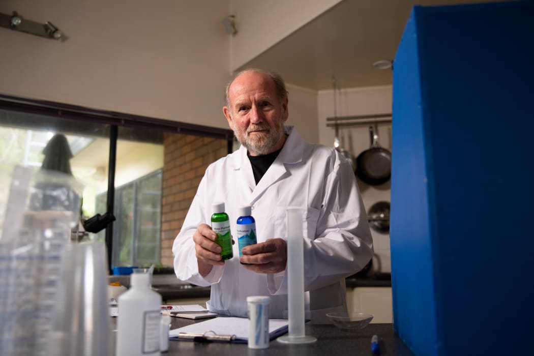 Forensic scientist Dr Ian Calhaem holding sodium chlorite and hydrochloric acid.