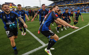 Auckland FC players celebrate victory over Wellington Phoenix with their fans, Dec 2024.
