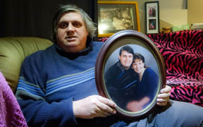 Laurie Anderson holds a photo of himself with partner Angela Blackmoore, who was murdered in their home 20 years ago.