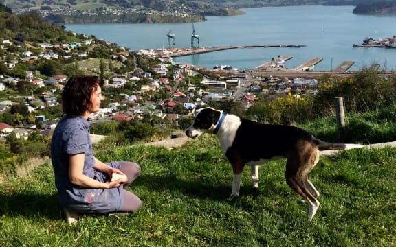 Hannah Beehre and her dog Scout with the view over Lyttelton