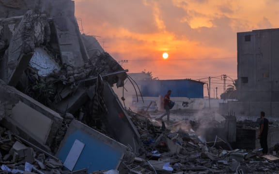 People inspect a building destroyed in Israeli strikes in Gaza City on October 8, 2023. Fighting between Israeli forces and the Palestinian militant group Hamas raged on October 8, with hundreds killed on both sides after a surprise attack on Israel prompted Prime Minister Benjamin Netanyahu to warn they were "embarking on a long and difficult war". (Photo by Mohammed ABED / AFP)
