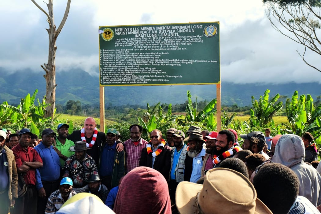 Councilors lining up with PNG's Western Highlands Provincial Administrator, Joseph Neng and ICRC Mt Hagen Head of Office, Kakhaber Khasaia, in front of the sign with the 15 tribal rules on it.