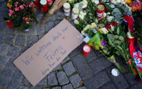 24 August 2024, North Rhine-Westphalia, Solingen: People lay flowers and light candles in Neumarkt in memory of the victims of the knife attack at the Solingen town festival. Several people were killed and injured in a knife attack on Friday evening at the city festival celebrating the 650th anniversary of the city of Solingen. Photo: Henning Kaiser/dpa (Photo by HENNING KAISER / DPA / dpa Picture-Alliance via AFP)