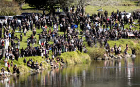 Crowds watch the waka transporting Kiingi Tuheitia's body