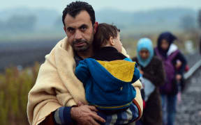 A migrant family arrives in Hungary in rainy weather at the Hungarian-Serbian border near Roszke on September 10, 2015.