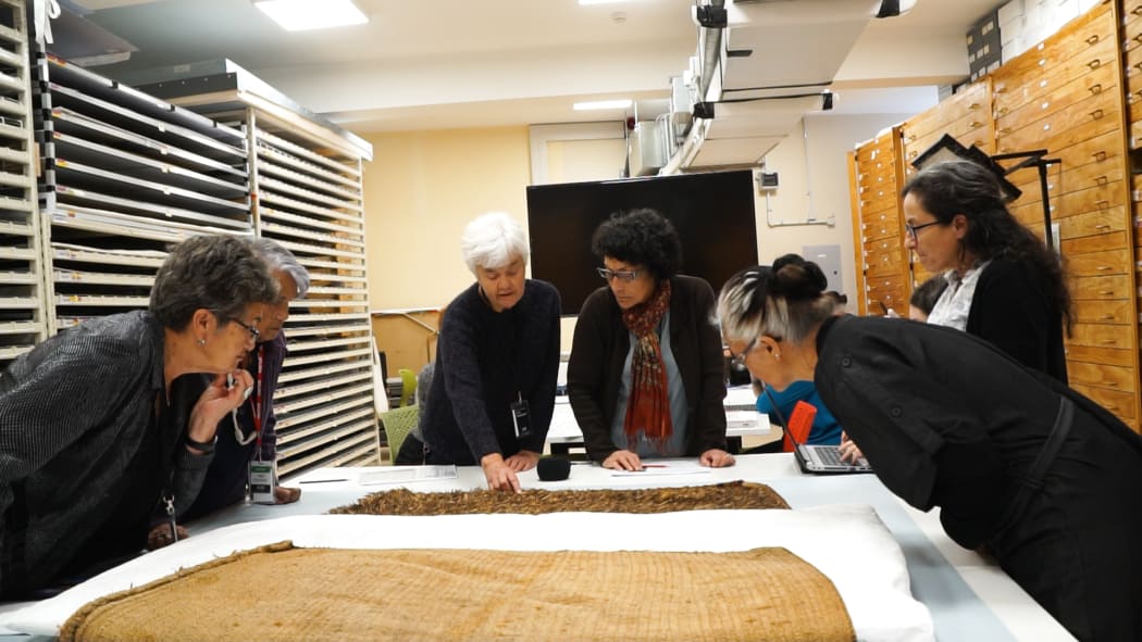 Christina Wirihana, Matekino Lawless, Dr Maureen Lander, Rangi Te Kanawa, Lisa McKendry and Awhina Tamarapa discussing a kahuhuruhuru (feather cloak).