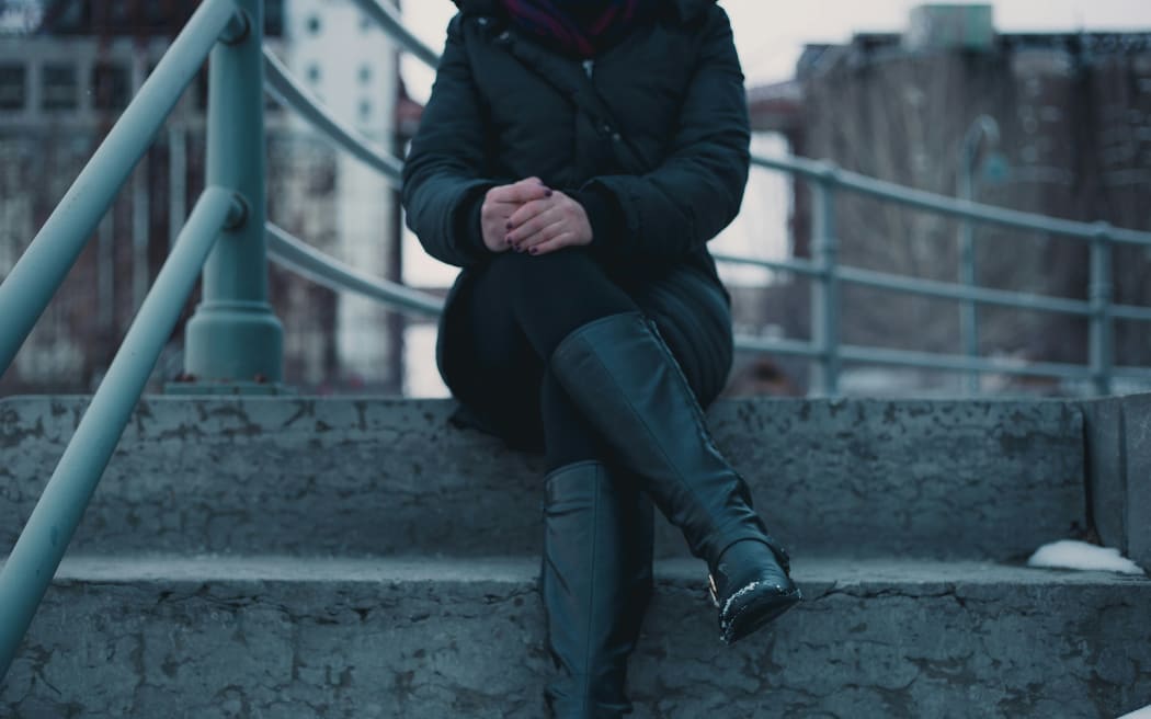 A woman waiting with crossed legs on steps