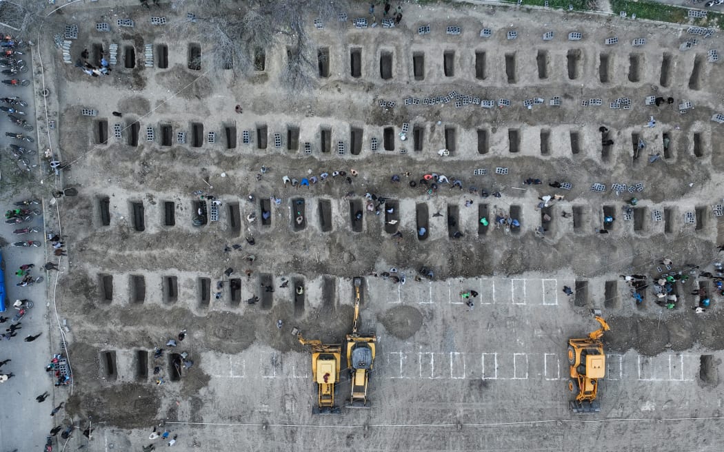 In this aerial handout picture released by the Iranian Press Center, mourners dig graves during the funeral for children killed in a reported strike on a primary school in Iran’s Hormozgan province in Minab on March 3, 2026. Iranian media have reported hundreds of Iranian casualties, including at a girl's school, although AFP reporters have not been able to verify tolls independently. The war launched by the United States and Israel against Iran spread across the Middle East, threatening to plunge the global economy into chaos, with Lebanon and Gulf energy exporters dragged into the conflict. (Photo by Iranian Press Center / AFP) / XGTY / RESTRICTED TO EDITORIAL USE - MANDATORY CREDIT "AFP PHOTO / IRANIAN PRESS CENTER" - HANDOUT - NO MARKETING NO ADVERTISING CAMPAIGNS - DISTRIBUTED AS A SERVICE TO CLIENTS