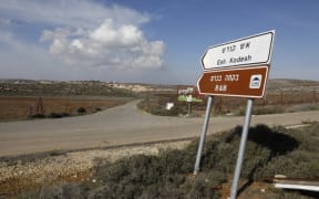 A road sign points towards an airbnb apartment, located in the Esh Kodesh outpost, near the Jewish settlement of Shilo and the Palestinian village of Qusra in the occupied West Bank on November 20, 2018. Airbnb said  it will remove such listings. (Photo by MENAHEM KAHANA / AFP)