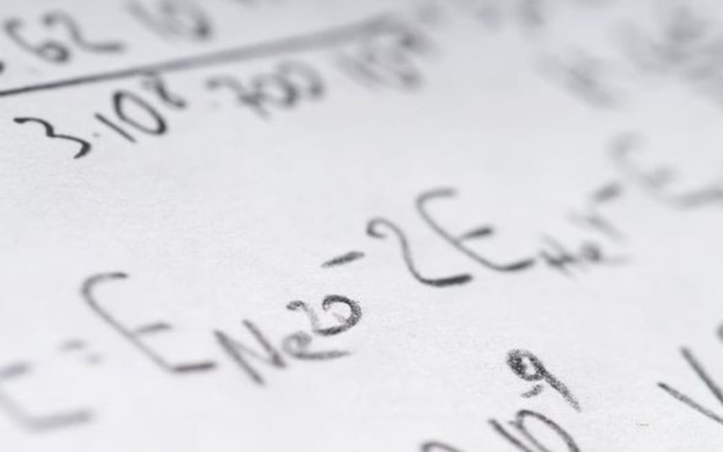 Maths book open with math problems written down