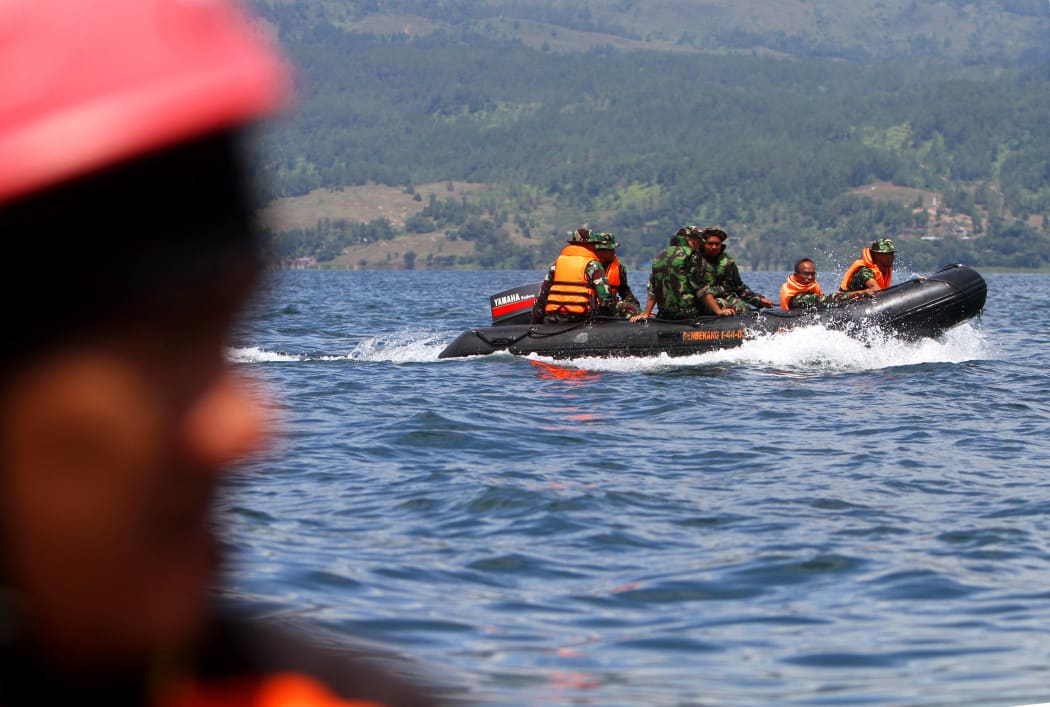 Rescue team members search for missing passengers on Lake Toba in the province of North Sumatra.