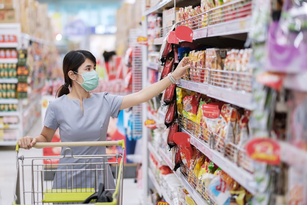 Young woman wearing protective face mask and  shopping in grocery or department store protect coronavirus inflection. social distancing, new normal and life under covid-19 pandemic