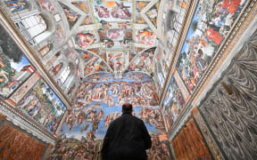 A man visits the Sistine Chapel on the reopening day of the Vatican museum on February 1, 2021 in Vatican City, as the city-state eases its closure aimed at curbing the spread of the COVID-19 infection, caused by the new coronavirus. (Photo by Andreas SOLARO / AFP)