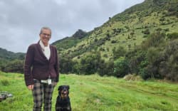 Celia Wade-Brown with Skye on her regenerating land in the Mangatarere Valley