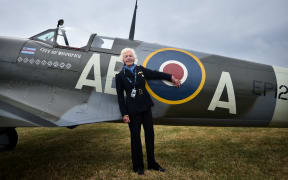 Battle of Britain veteran, pilot First Officer Mary Ellis, poses with a Spitfire aircraft.