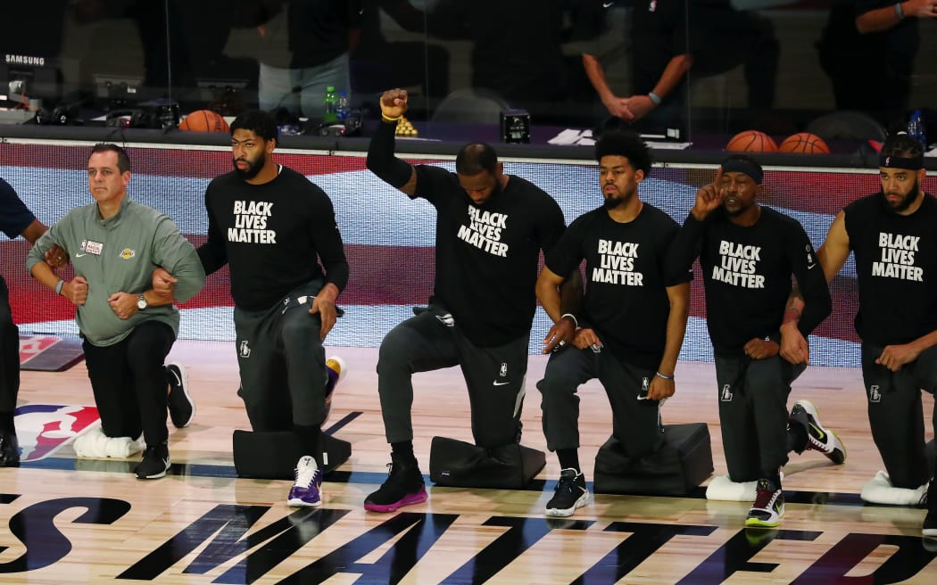 LeBron James #23 of the Los Angeles Lakers and the Los Angeles Lakers kneel during the national anthem before a NBA basketball game against the Indiana Pacers.