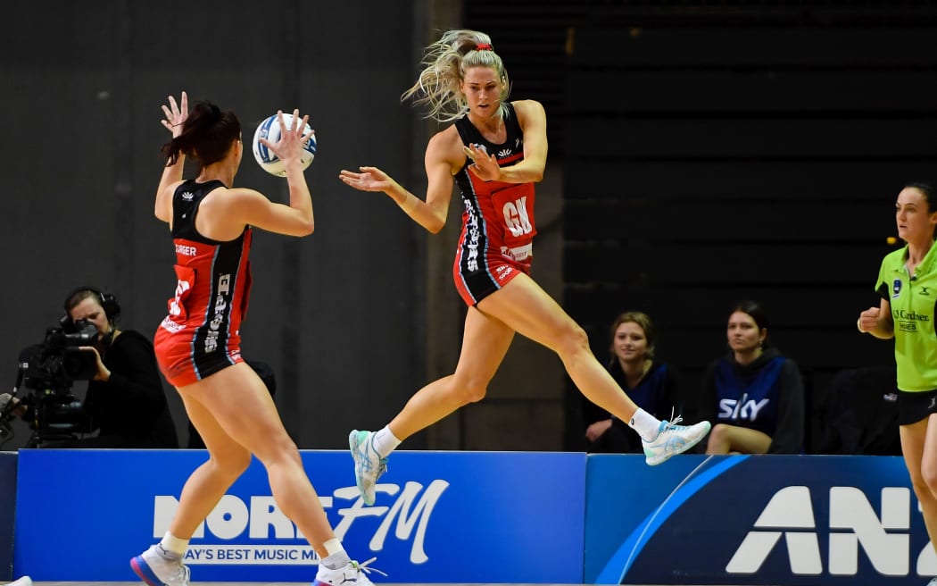 Jane Watson of the Tactix passes the ball to Karin Burger.