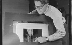 Raymond Boyce, set designer for the New Zealand Players, with a miniature model of a stage and set. Evening post (Newspaper. 1865-2002) :Photographic negatives and prints of the Evening Post newspaper.