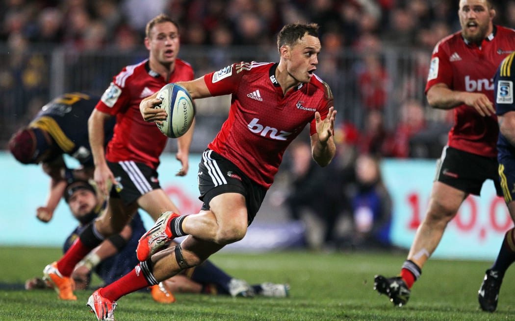 Israel Dagg of the Crusaders runs with the ball in hand against the Highlanders in Christchurch.