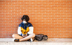 Perpignan, June 10, 2020, Classes resume at the Lycée Arago in Perpignan. History class with wearing of the mask for the teacher and the students. High school student waiting between two classes on his mobile phone and wearing the mask.