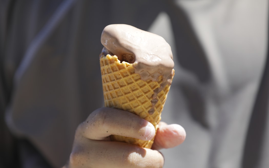 Boy eats an icecream. Summer in Eastbourne, Wellington.