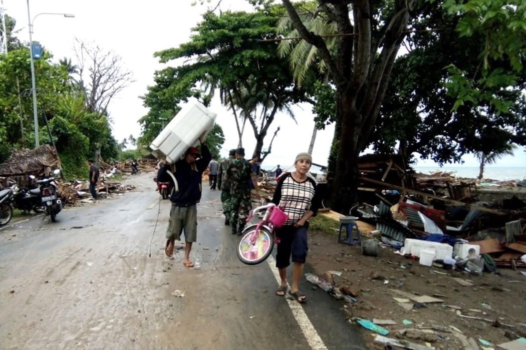 Residents evacuate from damaged homes on Carita beach on December 23, 2018, after the area was hit by a tsunami on December 22 that may have been caused by the Anak Krakatoa volcano. AFP
