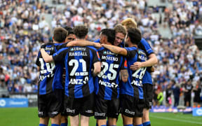 Auckland FC players celebrate a goal against the Wellington Phoenix.