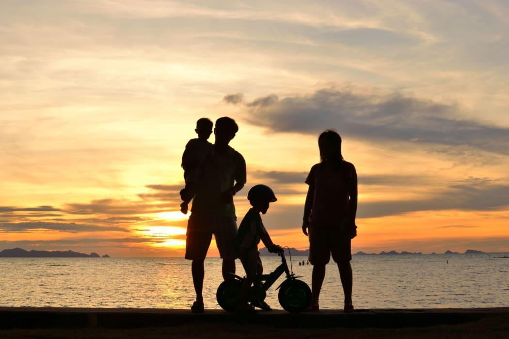silhouette of family on the beach at dusk.