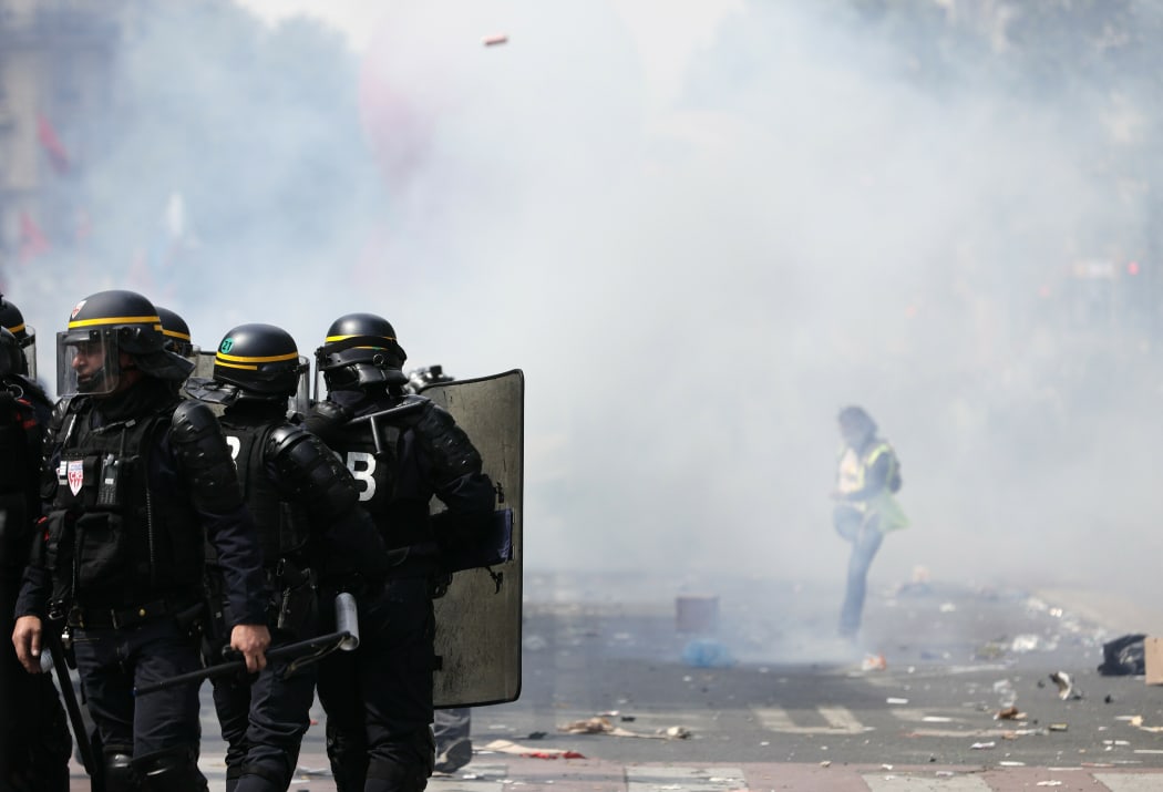 A protestor kicks away a tear gas canister during the protest.