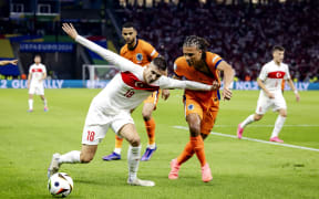 Mert Muldur of Turkey and Nathan Ake of Holland (l-r) during the UEFA EURO 2024 quarter-final match between the Netherlands and Turkey at the Olympiastadion on July 6, 2024 in Berlin, Germany.