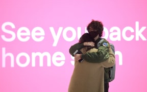 Family members embrace at the departure lounge at Sydney's International Airport on November 1, 2021, as Australia's international border reopens almost 600 days after a pandemic closure began.