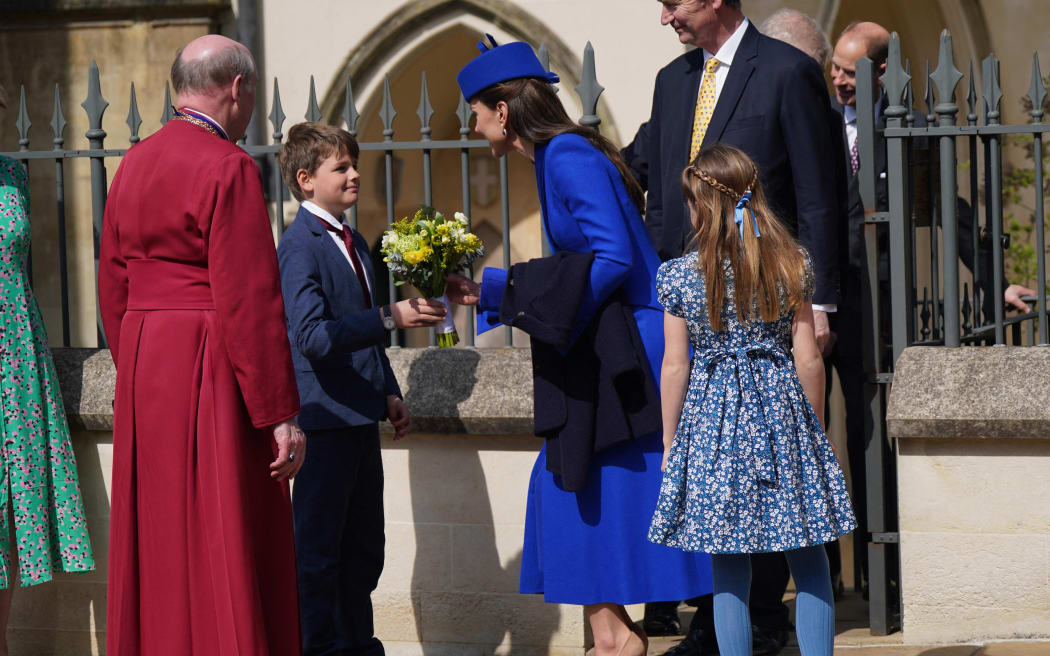 Britain's Catherine, Princess of Wales (C) receives a posy from Samuel, aged 8 after attending the Easter Mattins Service at St. George's Chapel, Windsor Castle on 9 April, 2023.