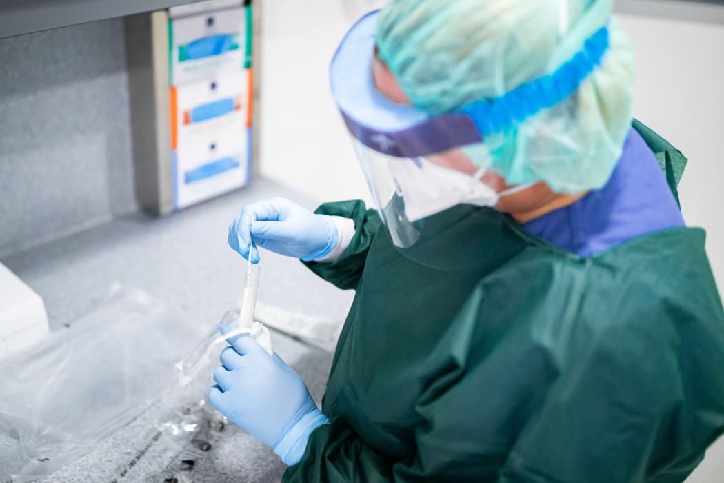 Person in protective clothing and with a breathing mask in an airlock.