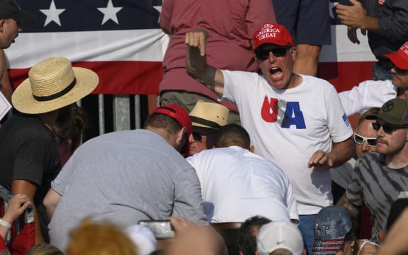 BUTLER, PENNSYLVANIA - JULY 13: Attendees scatter after gunfire rang out during a campaign rally for Republican presidential candidate, former U.S. President Donald Trump at Butler Farm Show Inc. on July 13, 2024 in Butler, Pennsylvania. Trump slumped before being whisked away by Secret Service with injuries visible to the side of his head. Butler County district attorney Richard Goldinger said the shooter and one audience member are dead and another was injured.   Jeff Swensen/Getty Images/AFP (Photo by JEFF SWENSEN / GETTY IMAGES NORTH AMERICA / Getty Images via AFP)