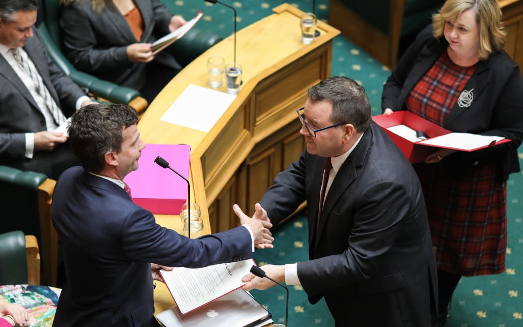 Grant Robertson gives a copy of the budget speech to David Seymour